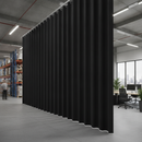 Solid black PVC strip curtains dividing UK warehouse into separate zones — noise and privacy barrier